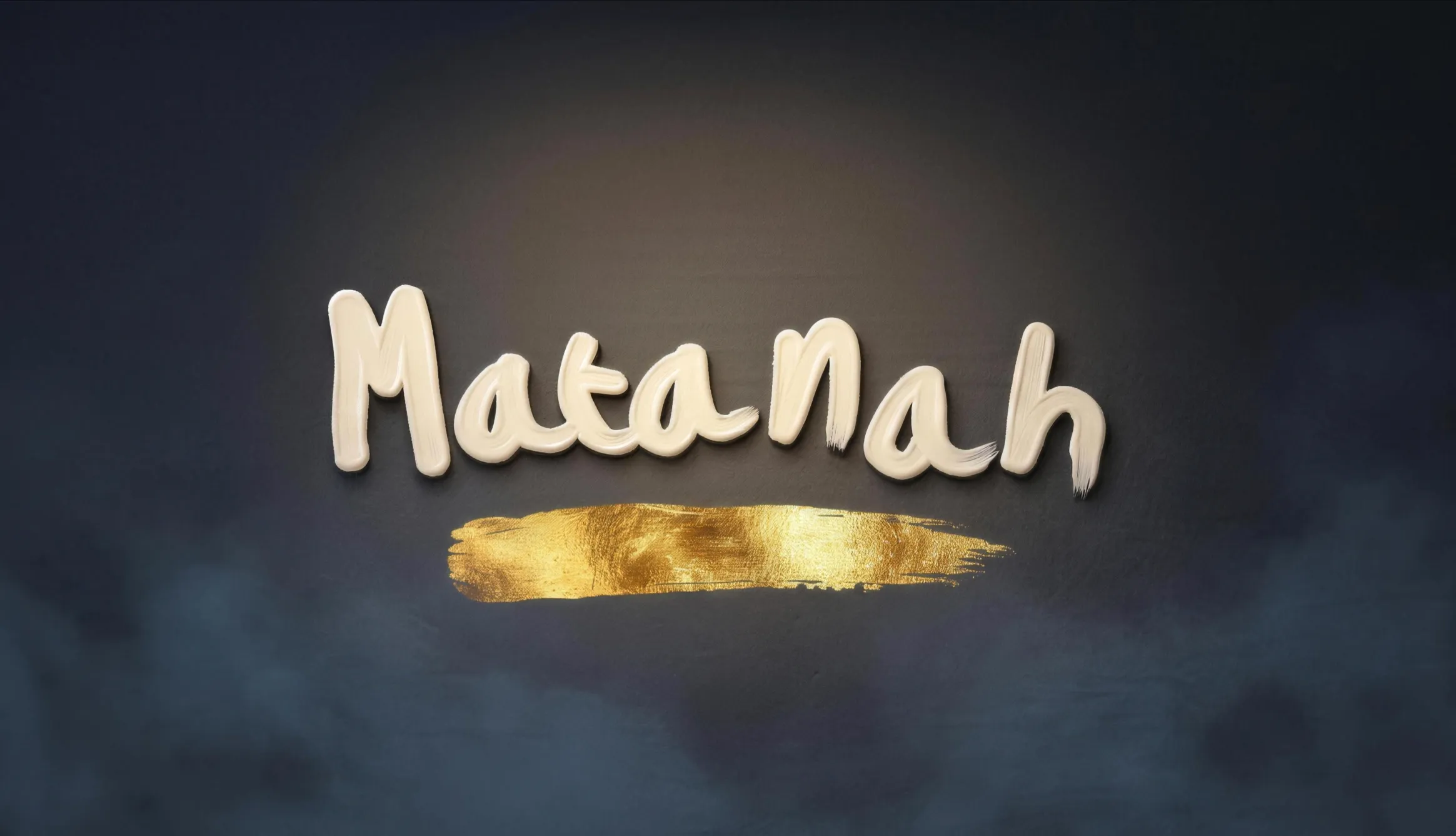 The Matanah wordmark in ivory enamel on a slate wall, with a gold leaf stroke beneath it